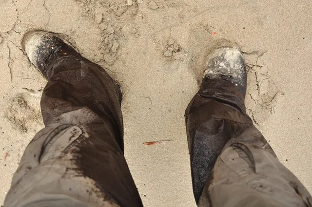 Contrasting white sand on filthy muddy boots