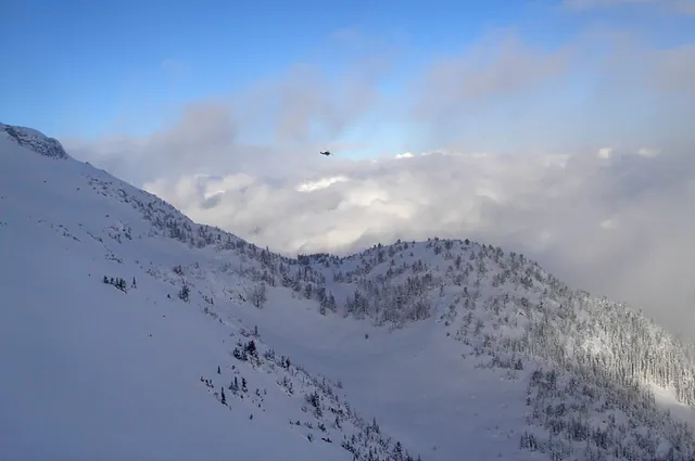 The helicopter takes off and will return later to lift us up to another run