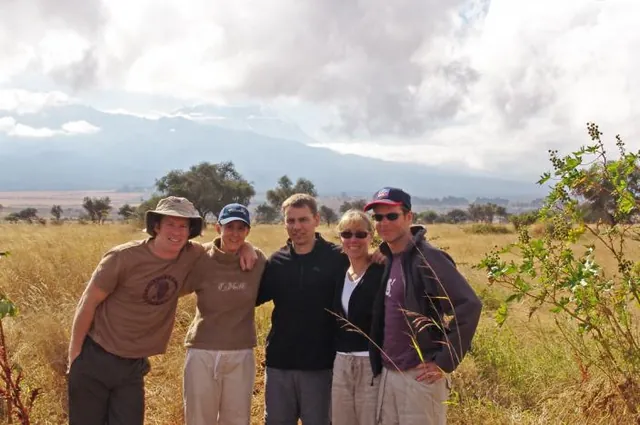 The Kili climbers pose for a picture at the base, with the summit in view behind