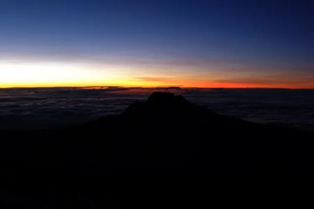Mweka crag silhouetted by the colourful sunrise