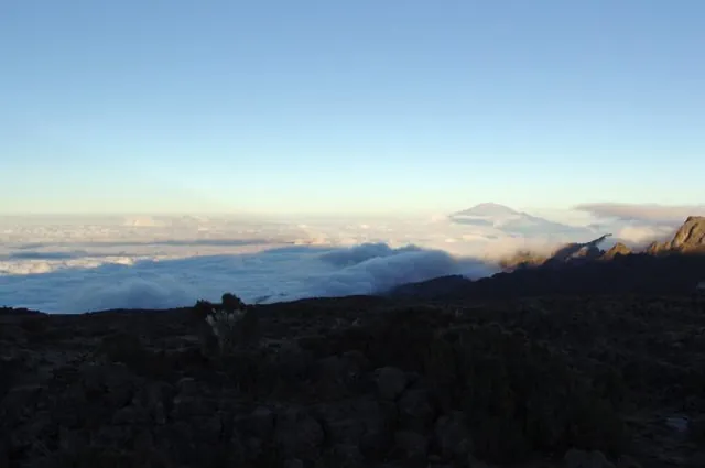 The morning sun reveals a blanket of cloud beneath us and Mount Meru in the distance