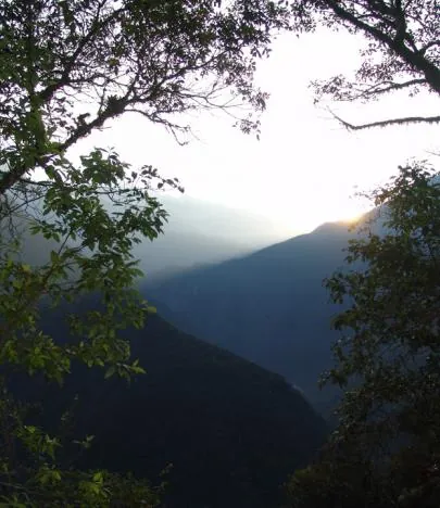 The sun starts to rise over the misty horizon ... we set out from the foot of Machu Picchu mountain