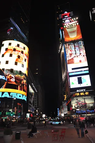 Times Square at midnight. The girls dwarfed by the huge LED displays