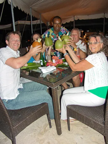 Taking our seats for the Melanesian Feast - Gill obscured by coconuts