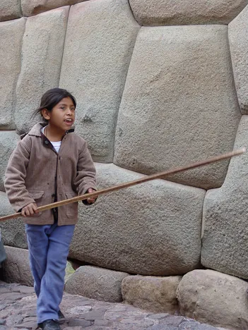 A young kid on the street fleecing tourists to point out the mystical puma shape in the stones
