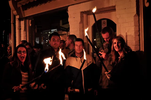 Gang assembled with torches lit waiting for the parade