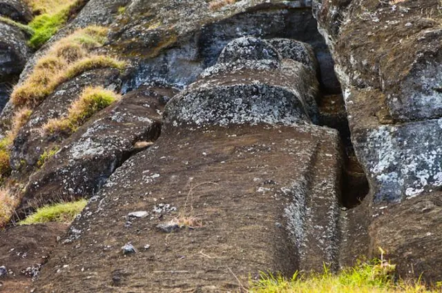 A Moai in the process of being carved out of the stone wall.
