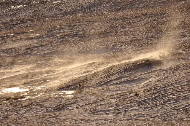 A hiker making his way down an alternative path in the swirling snowy winds