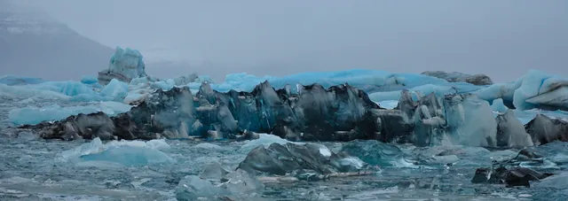 Black icebergs, presumably covered in ash from the recent eruption