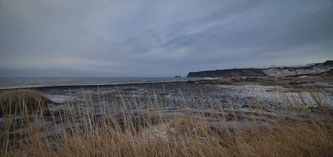 The frozen black sands at Vik atop a grassy bank