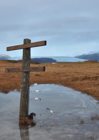 A large fence post with Breiðamerkurjökull in the background